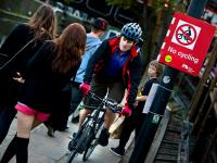 Cyclist On The Tow Path Pushing Through Pedestrians : Camden Lock : London
